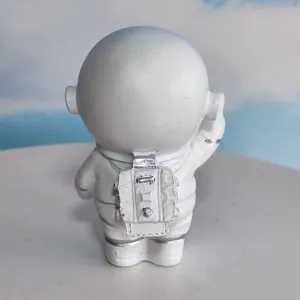 Closeup detail of a white astronaut figurine back design with silver backpack decoration.