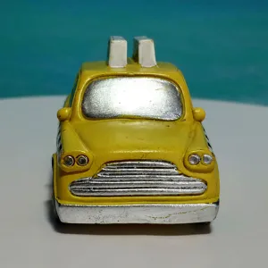 Detailed close-up of a yellow taxi card holder toy model, featuring silver painted grille.