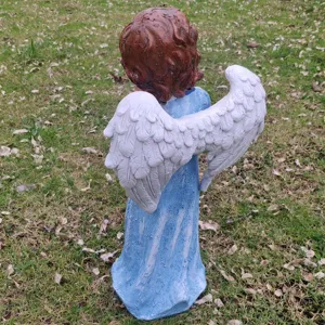 Resin garden angel statue with white wings and blue dress for outdoor courtyard decoration detail.