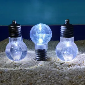 Detailed view of mini LED bulbs placed on sand surface, creative decorative lighting item.