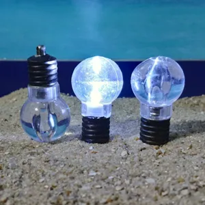 Detail shot of transparent miniature LED light bulbs placed on sand for decoration.