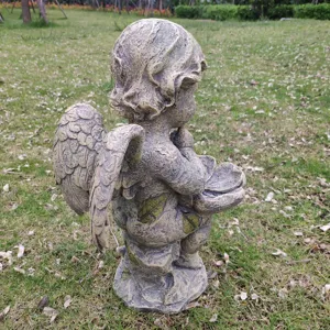 Detailed close-up of a vintage resin angel garden statue featuring a bird feeder bowl.