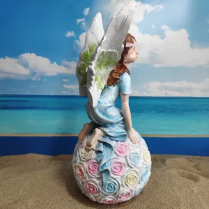 Detailed view of resin angel flower fairy figurine sitting on rose ball for garden yard decor.