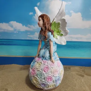 Resin angel fairy figurine garden ornament with pastel rose ball base for outdoor decor.
