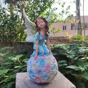 Resin angel fairy sitting on rose flower ball, exquisite garden decor detail shot for yard.