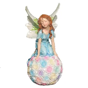 Resin fairy angel figurine sitting on a pastel rose flower ball garden ornament statue