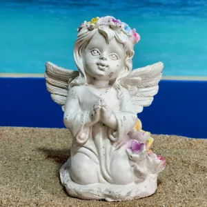 Vue rapprochée de la figurine d'ange vintage montrant une pose de prière et une couronne de fleurs.