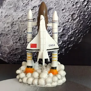 Space shuttle model ornament with rocket launch base and moon background for display.