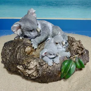 Resin koala family ornament detail shot showing cute mother and baby koalas on tree log decor.