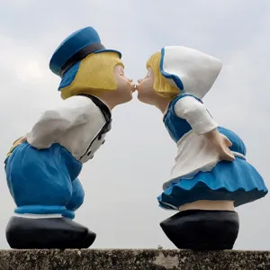 Detail view kissing couple garden statue, European resin figurine ornament for outdoor yard decor.