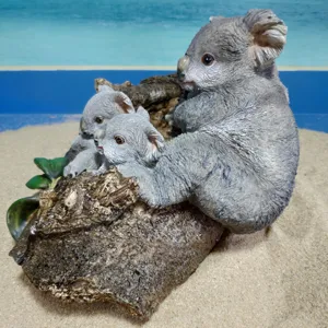 Detailed view of the resin koala figurine family on a tree log, perfect for home decor.