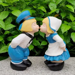 Detail view of cute kissing boy and girl garden ornament statue for outdoor courtyard decor.