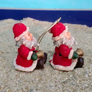 Resin Santa Claus hanging ornament detail view, miniature figurine with bell and gold cord.