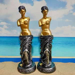 Detailed view of resin Greek goddess Venus statues with golden finish and beach backdrop.