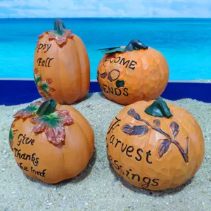 Detailed shot of resin pumpkin ornaments with engraved harvest blessing text for fall decor.