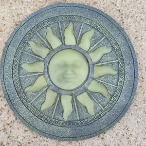 Vista de detalle de la piedra de paso para jardín con cara de sol de resina texturizada.