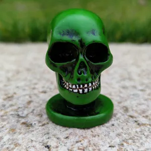 Green skull figurine Halloween decoration spooky prop for psychological sandbox photography item.