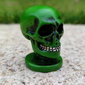 Green skull figurine, Halloween decor, psychic sandbox prop, miniature spooky skeleton head model.