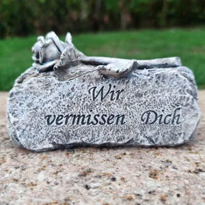 Memorial grave marker detail, resin rose stone ornament, outdoor cemetery remembrance decor.