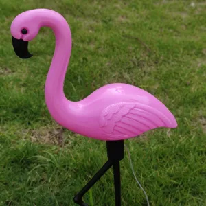 Outdoor solar flamingo garden light detail closeup view, vibrant pink resin lawn stake decoration.