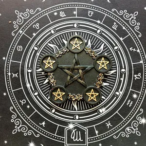 Close-up detail of the black and gold resin pentagram altar ornament with vintage celestial background.