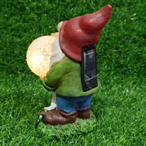 Solar garden gnome statue with glowing crackle glass ball resin outdoor yard light decor.