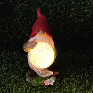 Solar garden gnome statue holding glowing cracked glass ball resin decorative light detail view