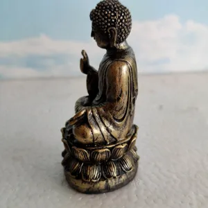 Side view detail of a vintage bronze Buddha statue on lotus base, meditation decor sand tray.