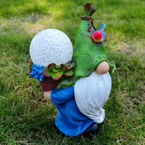 Garden solar gnome statue detail view, resin figurine with glowing glass ball and succulent plant.