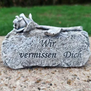 Memorial grave ornament with rose detail and German condolence text for departed loved ones.