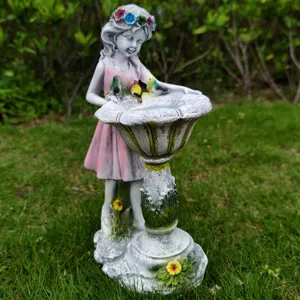 Resin garden fairy ornament detail showing birdbath and cute little birds on grass.
