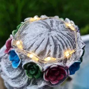 Resin solar garden light detail, decorative LED string light on floral sculpture.