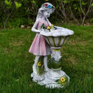 Detailed view of the resin garden fairy birdbath ornament placed on outdoor lawn.