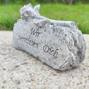 Detailed close-up of memorial stone ornament with engraved German text for grave decor.