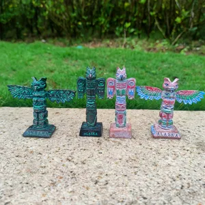 Detail view of four resin totem pole figurines, vintage tribal home decor and sand tray models.
