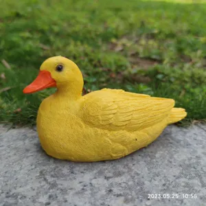 Cute yellow duck figurine detail, resin animal ornament for garden desktop decoration.
