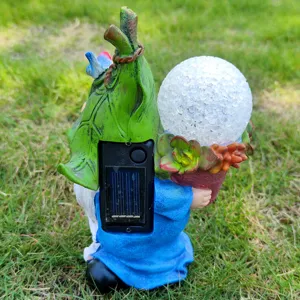 Detail view of solar garden gnome resin light, showing back solar panel and cracked glass ball.