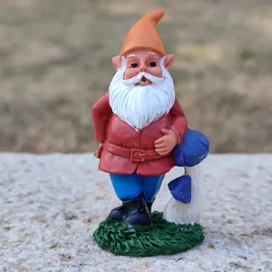 Gedetailleerde close-up van een schattig hars tuinkabouter beeldje met een paddenstoel.