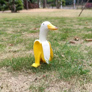 Creative banana duck statue detail showcasing vibrant yellow and white resin figurine texture on lawn.