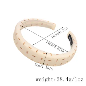 Serre-tete rembourre beige avec housse en tissu elegant, accessoire cheveux confortable.
