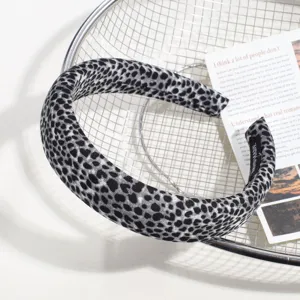 Gros plan détaillé d'un élégant serre-tête en tissu à motif léopard gris et noir sur un panier.