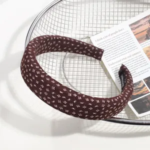 Gros-plan sur le serre-tête en tissu floral marron, accessoire élégant pour femme.