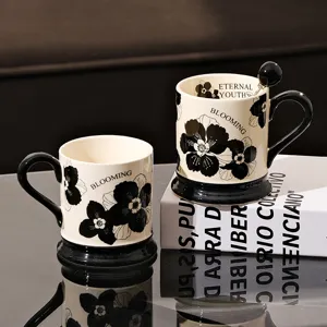 Retro ceramic coffee mug with black and white floral pattern, elegant cup with base for home office.