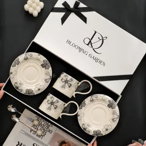 Retro keramieken koffiekop en schotel geschenkset, elegant zwart-wit bloemendesign voor thee.