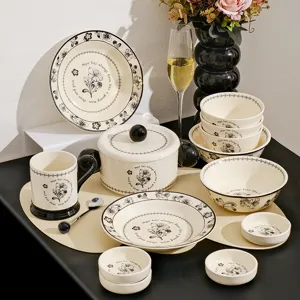 Elegante keramische servieserset met vintage zwarte bloemmotieven, complete kommen en borden.