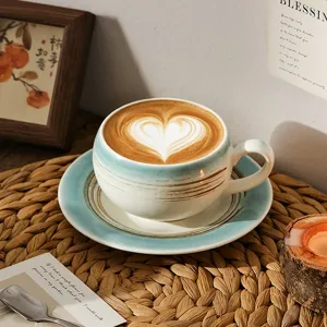 Detailopname van de keramische koffiekop en schotel, prachtig glazuur en fijne latte art.
