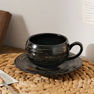 Zwarte keramische koffiekop en schotel set in vintage stijl voor gezellige middagthee momenten.