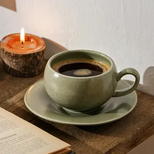 Detail van een mooie retro keramische koffiekop en schotel op een gezellige houten tafel.