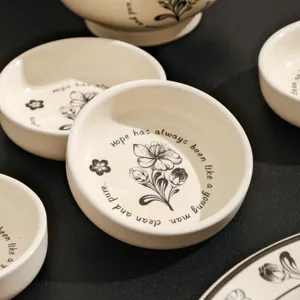 Set van kleine keramische schalen wit porselein servies met bloemen en engelse tekst.