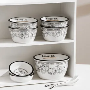Ceramic tableware set with bowls and spoons, black rim floral design for home use.